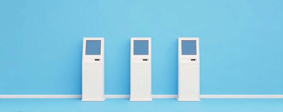 Three white interactive information kiosks standing in row against plain light blue wall providing digital self service access copy space