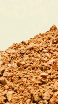 Large pile of raw red clay and soil at a construction site