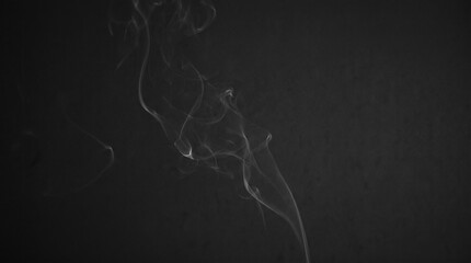 Fototapeta premium Minimalist photographic smoke wisps rising gracefully as delicate white tendrils against pure dark black background