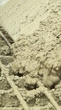 Wet concrete pouring over steel mesh rebar construction site