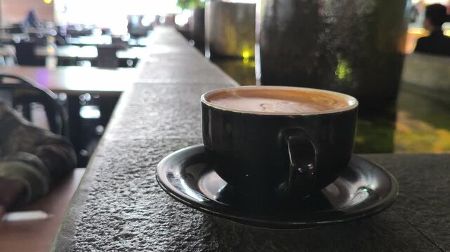 A person enjoying a cup of hot mochaccino topped with creamy foam, creating a cozy and relaxing caf&eacute; moment with rich coffee and chocolate flavors, perfect for lifestyle photography.