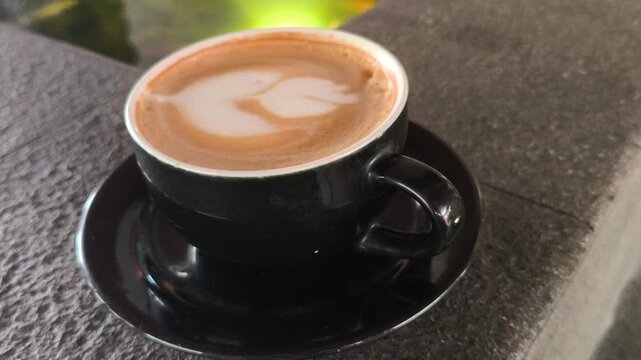 A person enjoying a cup of hot mochaccino topped with creamy foam, creating a cozy and relaxing caf&eacute; moment with rich coffee and chocolate flavors, perfect for lifestyle photography.