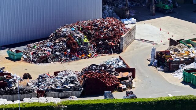 Large piles of scrap metal and industrial waste stored in an outdoor port facility