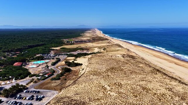 Aerial flyover reveals vast sand dunes pine forest and long Atlantic coastline at Plage des Oceanides France
