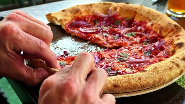 Male hands grabbing a delicious hot slice of pepperoni pizza from a plate in a pizzeria