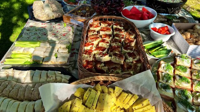 Assorted homemade dishes and fresh produce arranged on a picnic table outdoors