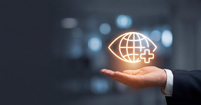 Global healthcare concept displayed as a glowing digital icon hovering above a professional hand against blurred office lighting background
