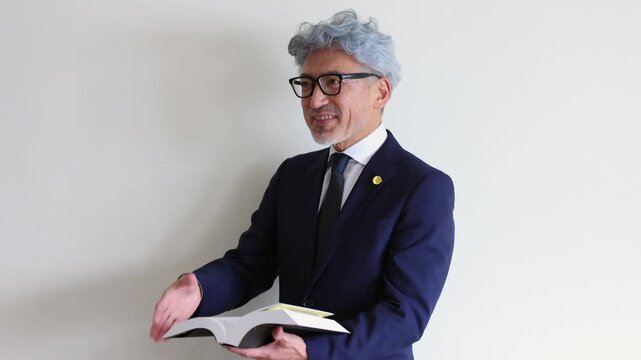 法律書を開いて説明する中高年の男性弁護士