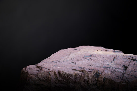 Natural Red Granite Stone Podium on Textured Black Background for Product Mockup.
