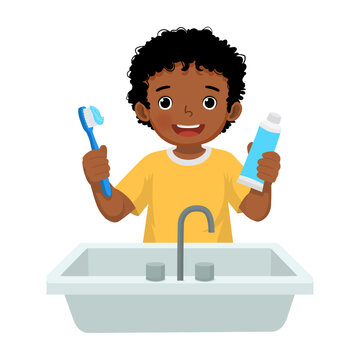 Little African boy brushing teeth holding toothbrush and toothpaste
