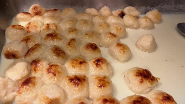 A mouth-watering close-up shot of freshly baked Rosogolla&mdash;spongy cottage cheese balls baked to perfection in caramelized thick milk (rabri)&mdash;displayed at a traditional sweet shop in Kolkata, West Benga