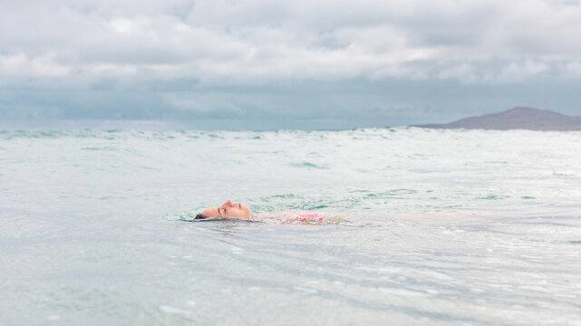 woman floating in pacific ocean