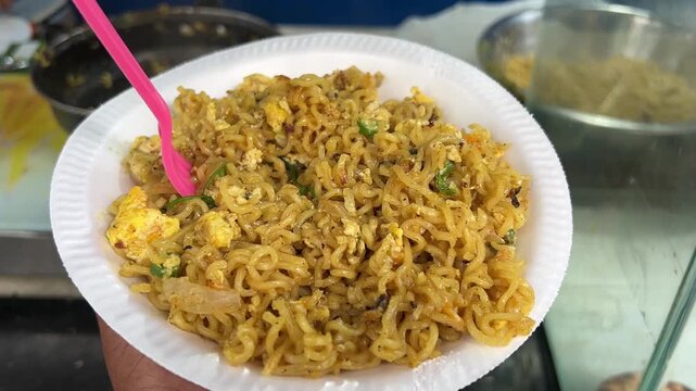 A mouth-watering close-up shot of steaming egg masala Maggi noodles served fresh at a lively highway dhaba that also specializes in charcoal-roasted litti chokha, India.