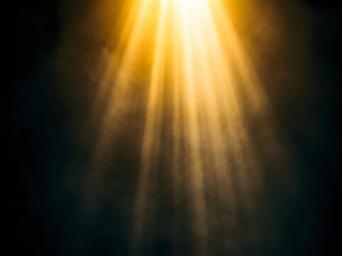 Abstract golden light rays shining from above creating a divine atmosphere on a dark black background