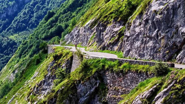 Athletic cyclist pedaling uphill on the steep and winding road of the Col d'Aubisque in France