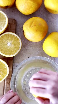 Top POV of orange juice freshly squeezed using glass citrus juicer. Vertical