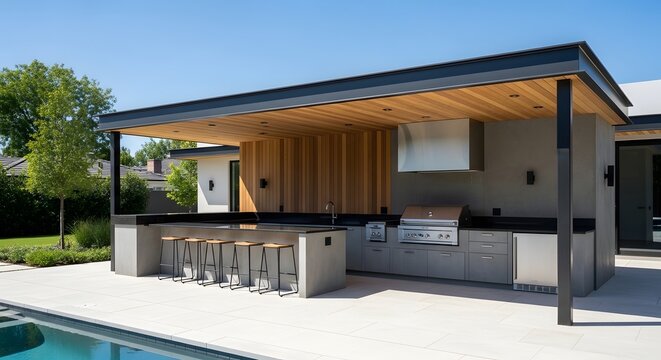 Modern outdoor kitchen and bar area with swimming pool in a luxury backyard.