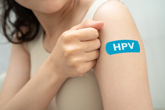 HPV, Human papillomavirus, Asian young woman receiving vaccine with blue bandage.