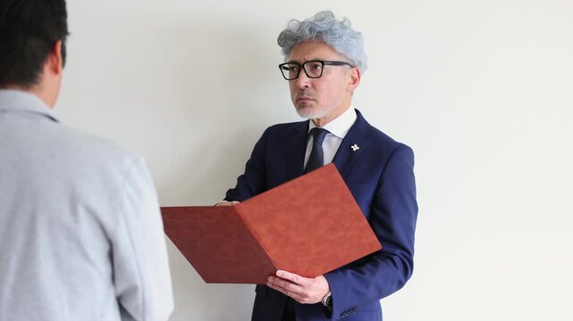 被告人に証拠を示しながら尋問する男性検察官