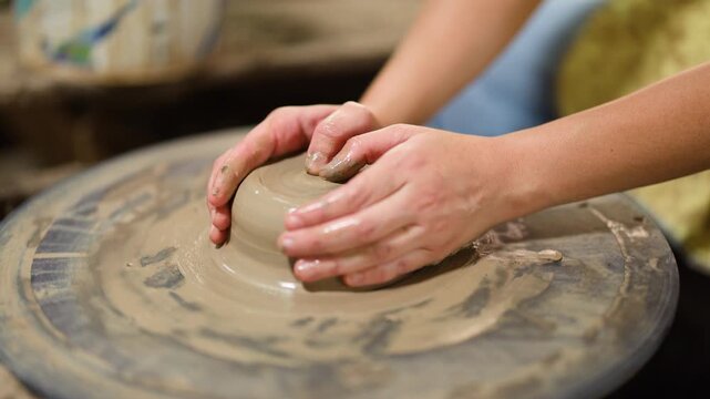 Artisan Hands Shaping Wet Clay on a Rotating Pottery Wheel