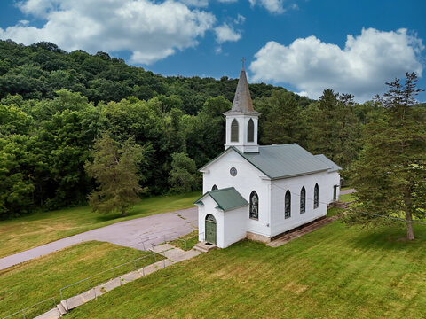Old fashioned White Country Church with Steeple in Peaceful Rural Landscape