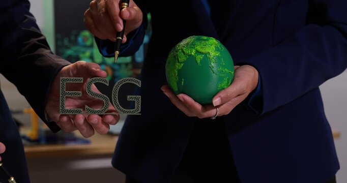 Business person holding esg letters and a green globe to show sustainability and corporate responsibility