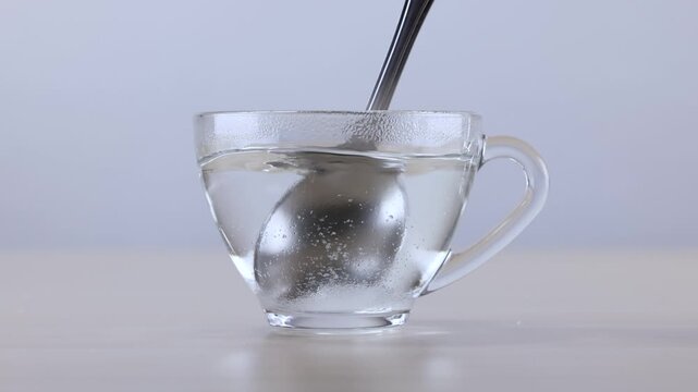 Stirring White Powder into Hot Water in a Glass Cup