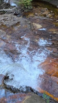 Waterfall Cascading Over Red Rock Ledge in Blue Mountains
