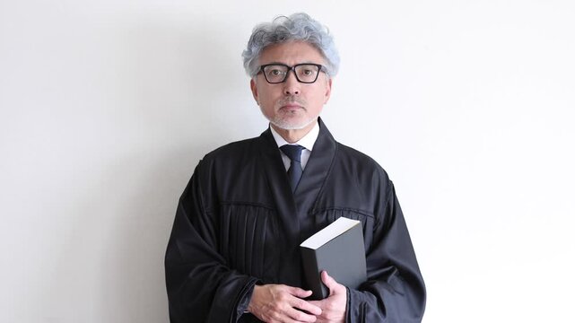 話を聞きながら静かに頷く法服姿の男性裁判官