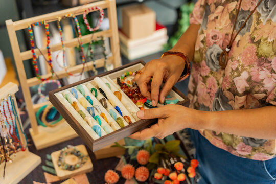 Asian Mature woman showing handcraft jewelry in hand for selling