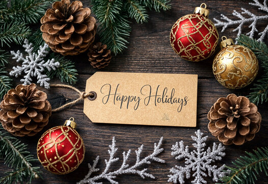 Festive holiday decorations with pinecones colorful ornaments and a happy holidays gift tag arrangement