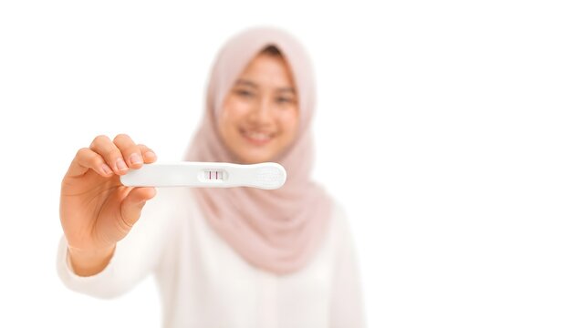 Smiling Muslim Woman Holding Positive Pregnancy Test Isolated on White Background