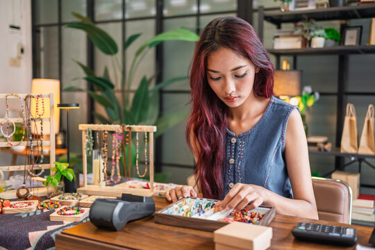 Asian Woman preparing handmade products for display inside small retail shop before opening sustainable small business growth.