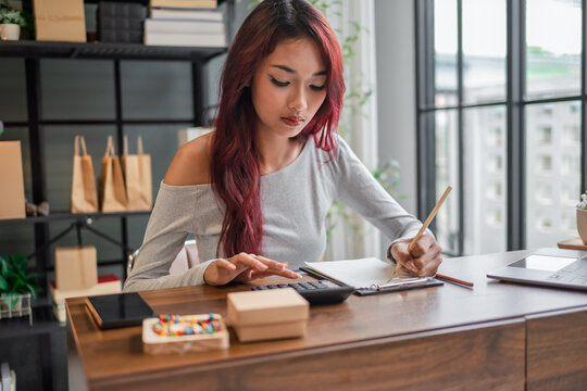 Woman managing small business accounts and recording sales revenue and expenses business income financial management entrepreneurship .