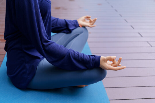 Asian Gen Z woman meditating on yoga mat alone in urban park promoting wellness mental wellbeing and healthy lifestyle wellness mindfulness and mental health.