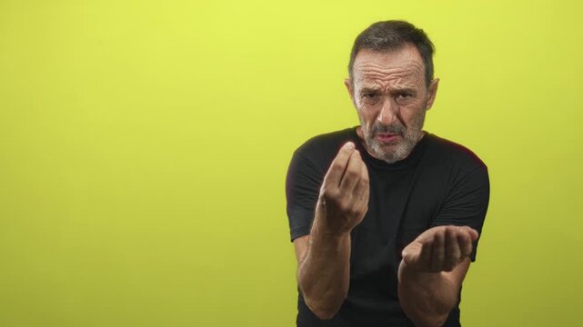 Man with raised hand performs a pointing gesture toward blank video frames in an empty studio building; isolation.