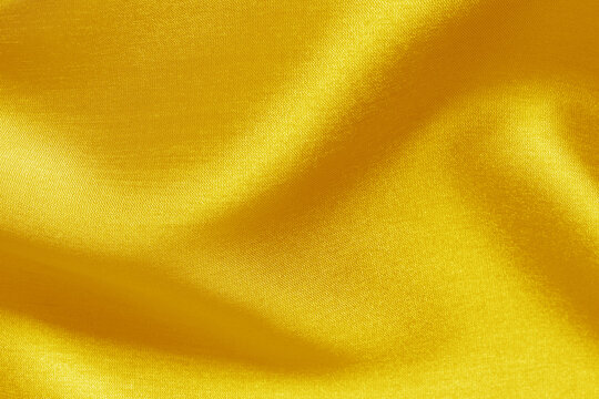 Yellow golden fabric cloth texture for background and design art work, beautiful crumpled pattern of silk or linen.