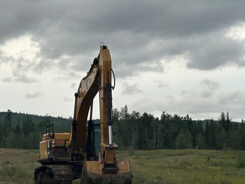 Heavy Equipment, Tractor in natural landscape with thunderclouds , August 8 2026 Alberta Canada. For editorial use only