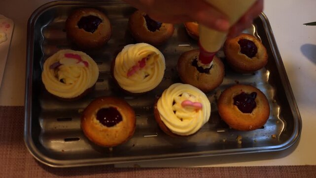 A pastry chef skillfully decorates cupcakes with smooth white frosting using a piping bag, creating an exquisite dessert in a bustling professional kitchen filled with mouth-watering aromas. Slow moti