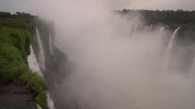 White-collared Swifts glide through the mist as Devil's Throat emerges from the spray, revealing the dramatic cliffs of Iguazu Falls in Misiones, Argentina.
