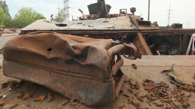 Slow upward camera movement revealing a destroyed Russian BMP-2 infantry fighting vehicle in Kharkiv, Ukraine, highlighting the burned interior and extensive damage following the invasion.