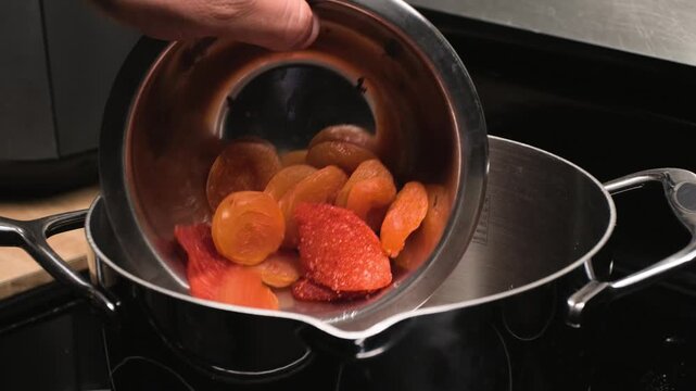 Close up cooking footage showing adding ingredients into pot for chamoy during a homemade chamoy sauce recipe prepared from scratch
