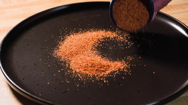 Close up cooking footage showing adding tajin spice to plate during a homemade chamoy sauce recipe prepared from scratch