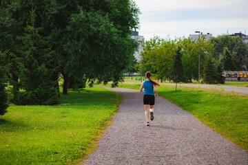 Fototapeta premium Woman Running in a Sunny Park During Morning Workout