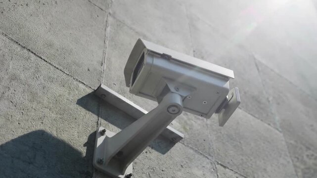 Security Camera Mounted on Concrete Wall Outdoor during Daytime with Sharp Focus and Minimalist Industrial Look for Safety or Surveillance Concept