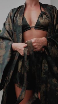Woman wearing coordinated kimono robe with matching bralette and lounge shorts.
