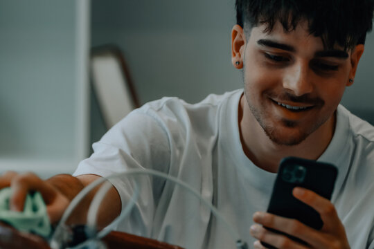 young man cleaning or preparing vintage bicycle looking at mobile phone or app