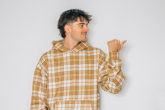 young man pointing isolated in background