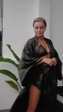 Woman wearing coordinated kimono robe with matching bralette and lounge shorts.