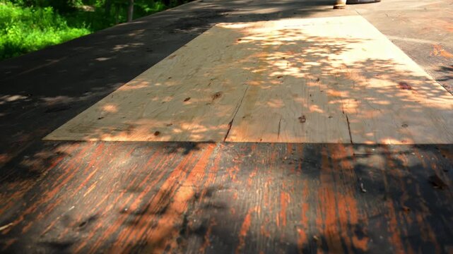 Construction worker installing roofing underlayment on a roof deck using OSB sheathing